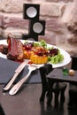 Grilled lamb ribs served with grilled corn, salat, bbq sauce, on a white plate