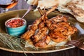 Grilled lamb steak on bone with thyme and tomato sauce served with glass of wine on a plate. Royalty Free Stock Photo