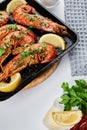 Grilled large queen shrimps with lemon and spices on the grill pan