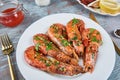 Grilled large queen shrimps with lemon and spices on the plate