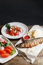 Grilled mackerel and a salad of fresh vegetables. Serving on a wooden Board on a rustic table. Barbecue restaurant menu Royalty Free Stock Photo