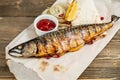 grilled mackerel and a salad of fresh vegetables. Serving on a wooden Board on a rustic table. Barbecue restaurant menu Royalty Free Stock Photo