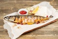 grilled mackerel and a salad of fresh vegetables. Serving on a wooden Board on a rustic table. Barbecue restaurant menu Royalty Free Stock Photo