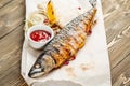 grilled mackerel and a salad of fresh vegetables. Serving on a wooden Board on a rustic table. Barbecue restaurant menu Royalty Free Stock Photo