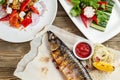 grilled mackerel and a salad of fresh vegetables. Serving on a wooden Board on a rustic table. Barbecue restaurant menu Royalty Free Stock Photo