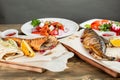 grilled mackerel and a salad of fresh vegetables. Serving on a wooden Board on a rustic table. Barbecue restaurant menu Royalty Free Stock Photo