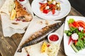 grilled mackerel and a salad of fresh vegetables. Serving on a wooden Board on a rustic table. Barbecue restaurant menu Royalty Free Stock Photo