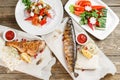 Grilled mackerel and sea bass. Salad of fresh vegetables. Serving on a wooden Board on a rustic table. Barbecue Royalty Free Stock Photo