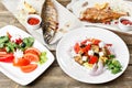 Grilled mackerel and sea bass. Salad of fresh vegetables. Serving on a wooden Board on a rustic table. Barbecue Royalty Free Stock Photo