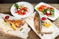 grilled mackerel and sea bass. Salad of fresh vegetables. Serving on a wooden Board on a rustic table. Barbecue Royalty Free Stock Photo