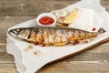 Grilled mackerel. Serving on a wooden Board on a rustic table. Barbecue restaurant menu, a series of photos of different Royalty Free Stock Photo