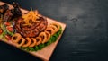 Grilled meat on the board. Sausage, ribs and fresh vegetables. On a wooden table. Royalty Free Stock Photo