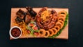 Grilled meat on the board. Sausage, ribs and fresh vegetables. On a wooden table. Royalty Free Stock Photo