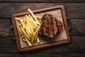 Grilled meat and fries presented enticingly on a wooden table