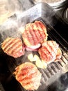 Grilled meat in a frying pan. Hot Grilled Steak. Three grilled beef tenderloin steaks coated bacon on a frying pan