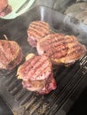 Grilled meat in a frying pan. Hot Grilled Steak. Three grilled beef tenderloin steaks coated bacon on a frying pan