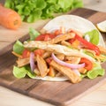 Grilled meat with onion and bell peppers, tomato,lettuce and serve with flour tortilla on wooden board. Royalty Free Stock Photo