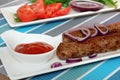 Grilled meat sausages with vegetables and ketchup. Kebab Royalty Free Stock Photo