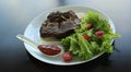 Grilled meat served with greens and pitta bread on white plate at the restaurant Royalty Free Stock Photo