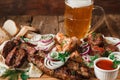 Grilled meat served with mug of cold beer close up Royalty Free Stock Photo