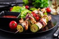 Grilled meat skewers, chicken shish kebab with zucchini, tomatoes and red onions.