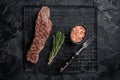 Grilled meat steak Machete skirt on a rack. Black background. Top view