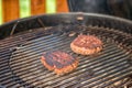 Grilled meat - two burntburgers on an outdoor grill Royalty Free Stock Photo