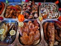 Grilled meats - fish, pork and grilled chicken in stainless steel trays