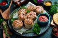 Grilled medallions wrapped in bacon. in a pan, ready to eat. On a black concrete background.