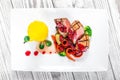 Grilled medium rare beef with pear, grilled vegetables, broccoli, berries sauce on plate on wooden background Royalty Free Stock Photo