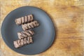 grilled minced meat, mici or mititei on a black ceramic plate and a wood board Royalty Free Stock Photo