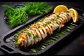 grilled monkfish tail with green herbs on a dark stone tray