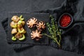 Grilled octopus. A side dish of roasted potatoes and celery. Black background. Top view Royalty Free Stock Photo