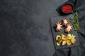 Grilled octopus. A side dish of roasted potatoes and celery. Black background. Top view. Space for text Royalty Free Stock Photo