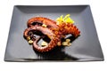 Grilled octopus tentacles on black plate on white Royalty Free Stock Photo