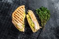 Grilled panini with Prosciutto ham, salad and cheese. Black background. top view