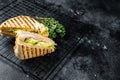 Grilled panini with Prosciutto ham, salad and cheese. Black background. top view. copy space