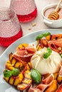 Grilled peach salad with mozzarella, prosciutto ham, basil, Delicious appetizer for wine, vertical image. top view Royalty Free Stock Photo