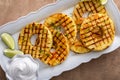 Grilled pineapple served with fresh lime wedges and whipped cream Royalty Free Stock Photo