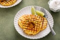 Grilled pineapple served with fresh lime wedges and whipped cream Royalty Free Stock Photo