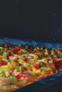 Grilled Pizza with sweet pepper, meat, vegetables, melted cheese, tomato and green olives. Selective focus, close-up. In oven. Royalty Free Stock Photo