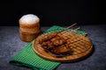 Grilled pork on bamboo skewers placed on a steel grill in a wooden tray with sticky rice in the cart, ready to serve Royalty Free Stock Photo