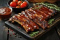 Grilled pork bbq ribs served with cherry tomatoes, basil and barbeque sauce on wooden cutting board on wood board. Royalty Free Stock Photo