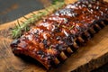 Grilled pork bbq ribs served with cherry tomatoes, basil and barbeque sauce on wooden cutting board on wood board. Royalty Free Stock Photo