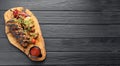 Grilled pork bbq ribs served with cherry tomatoes, pepper and barbeque sauce on wooden cutting board over dark Royalty Free Stock Photo