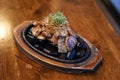 Grilled pork belly served on hot stones, Topped with chopped spring onions and rosemary leaf, Korean BBQ style. Royalty Free Stock Photo