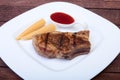 Grilled pork chop with Cranberry sauce and Mini Corn cob preserved on plate on wooden board Royalty Free Stock Photo