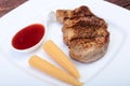 Grilled pork chop with Cranberry sauce and Mini Corn cob preserved on plate on wooden board Royalty Free Stock Photo