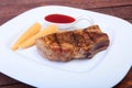 Grilled pork chop with Cranberry sauce and Mini Corn cob preserved on plate on wooden board Royalty Free Stock Photo