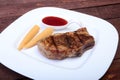 Grilled pork chop with Cranberry sauce and Mini Corn cob preserved on plate on wooden board Royalty Free Stock Photo